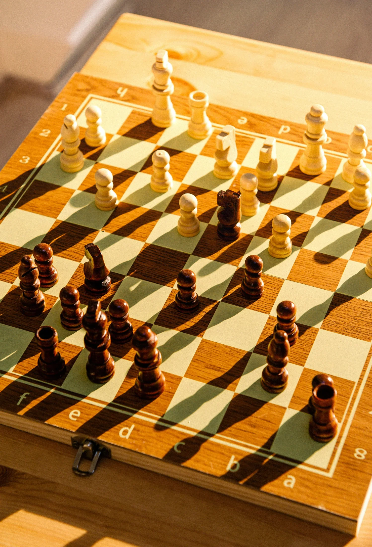 Sunlight across a wooden chessboard and pieces