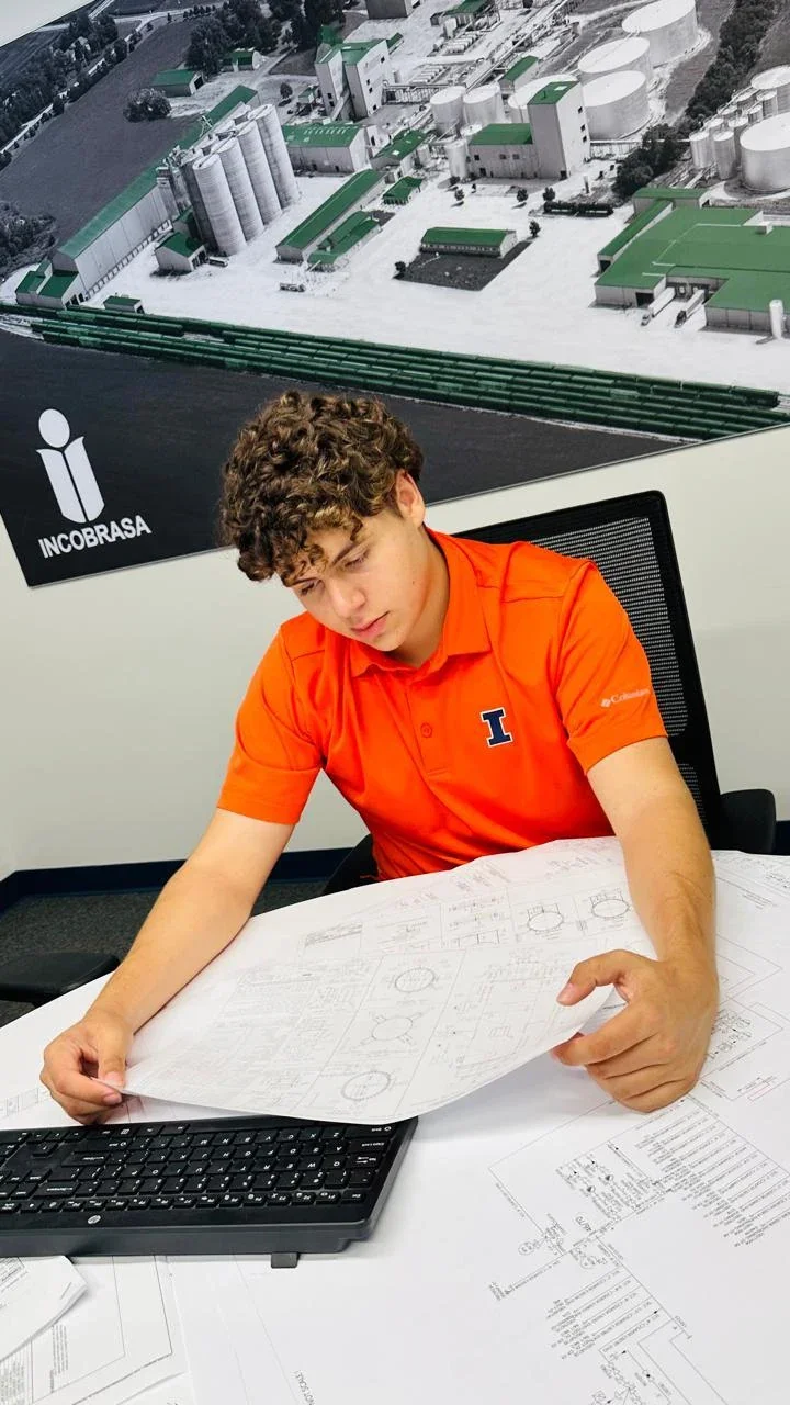 Pedro reviewing technical drawings at his desk during his Incobrasa internship